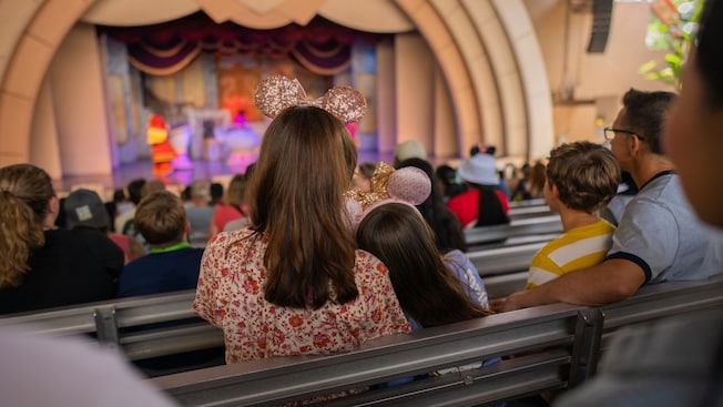 A family of 4 and other Guests watching the Beauty and the Beast Live on Stage show from the stands