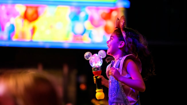 A happy young girl watching Disney Junior Mickey Mouse Clubhouse Live from near the stage
