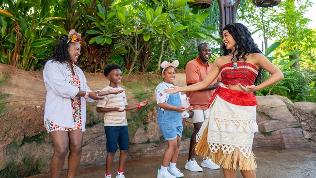 A family of 4 dancing with Moana at Discovery Island in Disney's Animal Kingdom theme park