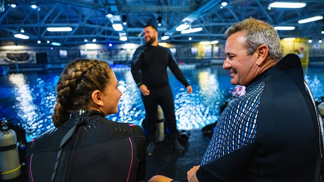 A teenage girl and her father, both in wetsuits at the Epcot DiveQuest facility  