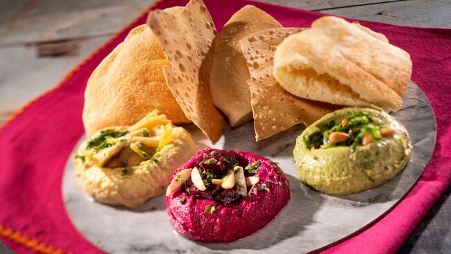 A trio of hummus served with Moroccan bread and papadam