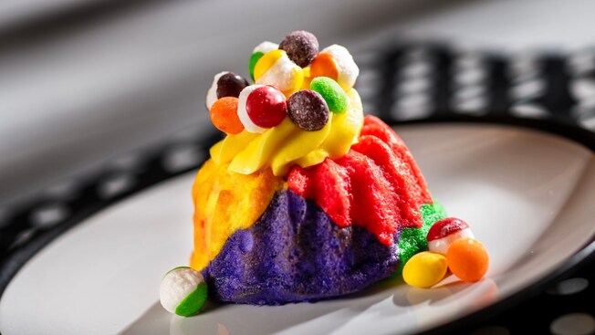 The Color Scheme Cake topped with whipped cream and pieces of candy	