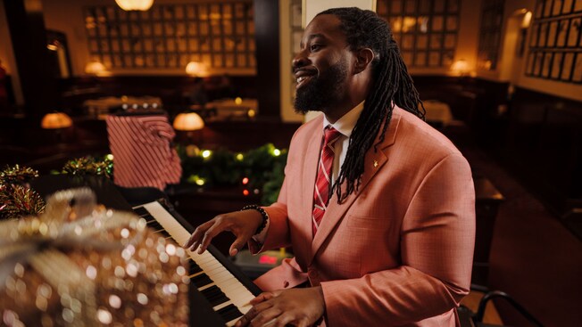 A man dressed in a suit, playing a piano in The Hollywood Brown Derby restaurant