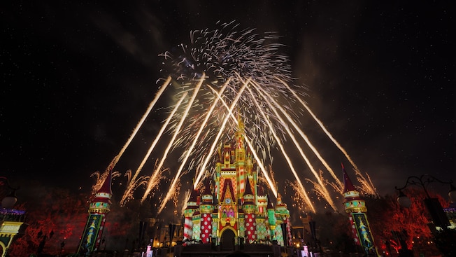 Fuegos artificiales explotando en el cielo sobre el Cinderella Castle en Minnie's Wonderful Christmastime Fireworks Show