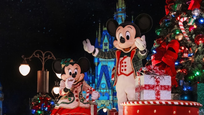 Mickey Mouse y Minnie Mouse con decoraciones navideñas frente al Cinderella Castle en Mickey's Very Merry Christmas Party