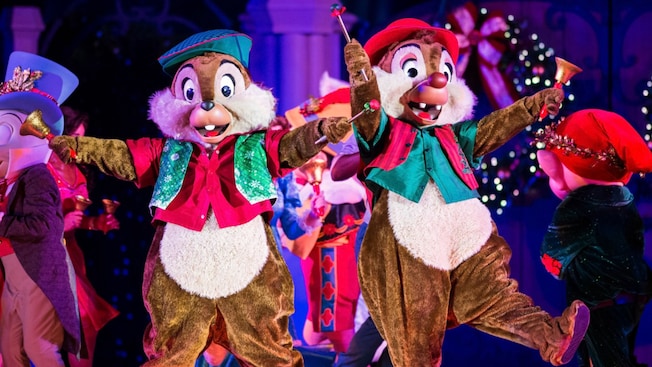 Chip y Dale sobre el escenario con los brazos extendidos durante Mickey’s Most Merriest Celebration en Mickey’s Very Merry Christmas Party