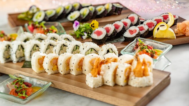 Three platters of sushi served with garnish