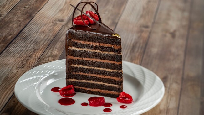 A slice of chocolate cake with berries on a round plate