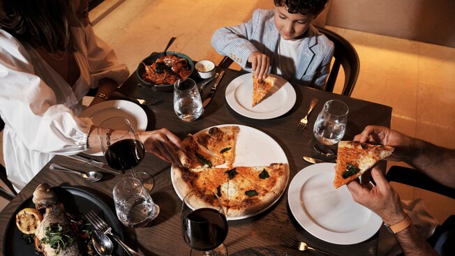 A family sharing a pizza in Ravello at the Four Seasons Resort Orlando