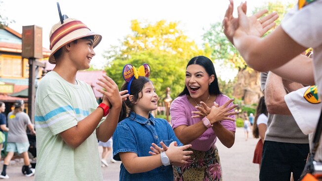 A family of 4 doing bird inspired hand signs along with a Cast Member in Disney's Animal Kingdom theme park