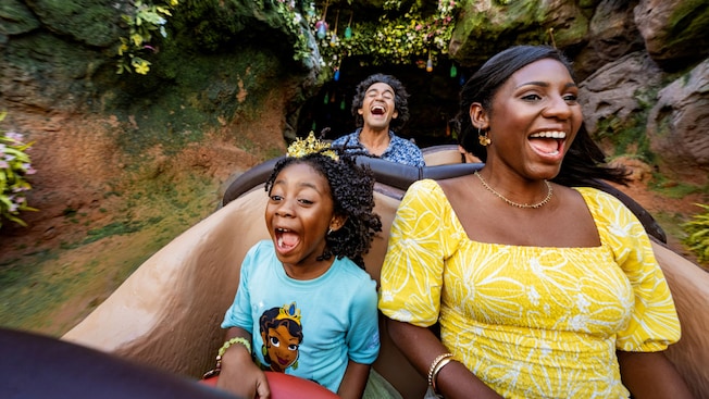 Guests smiling while riding down a drop at Tiana’s Bayou Adventure