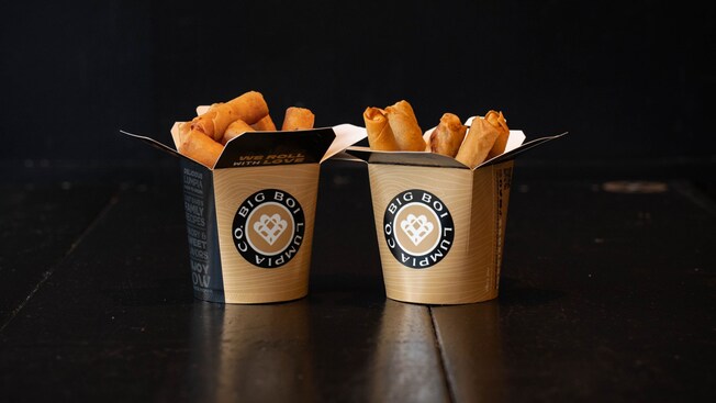 Two containers printed with Big Boi Lumpia Co filled with Filipino spring rolls