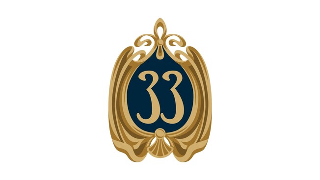 El logotipo de Club 33 con el número 33 enmarcado con espirales ornamentados, mostrado como un gráfico relleno