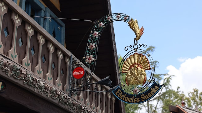 The ornate Edelweiss Snacks sign outside a Bavarian style building at Disneyland park