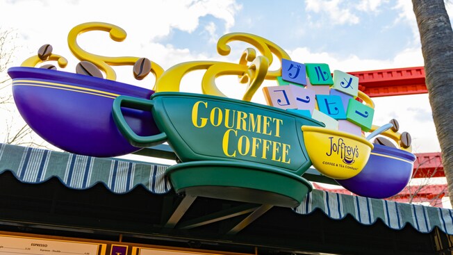 A sign that reads ‘Gourmet Coffee’ against a backdrop of cups at the Cappuccino Cart in San Fransokyo Square
