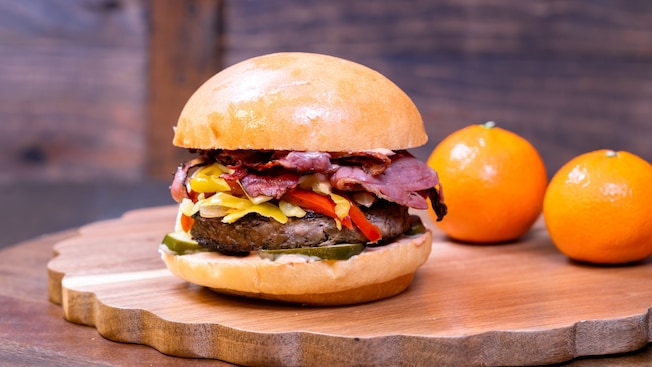 Una hamburguesa gourmet de Red Rose Taverne en Disneyland Park, con una hamburguesa de carne, pastrami, queso, pepinillos, cebollas salteadas y salsa alioli