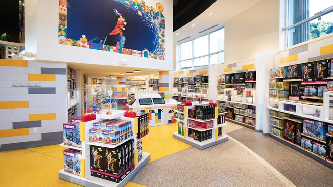 El interior de la tienda de Lego con exhibiciones de productos y un gran mural de Mickey el Brujo