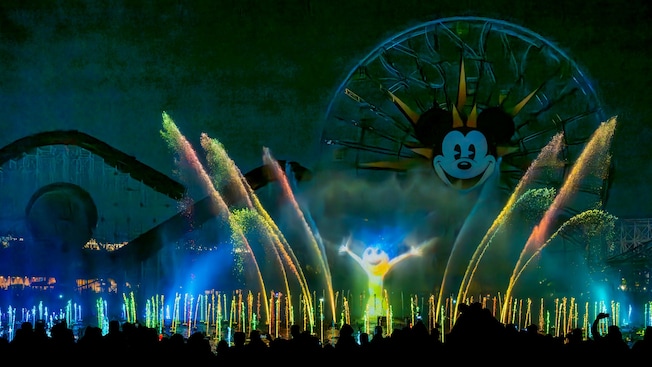Joy from Inside Out illuminated on the spray from fountains during the World of Color Happiness nighttime show