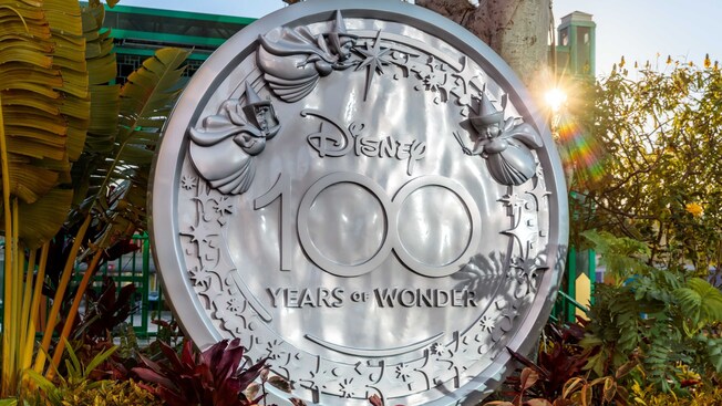 A sculpture of Disney fairies flying above the words 'Disney 100 Years of Wonder'