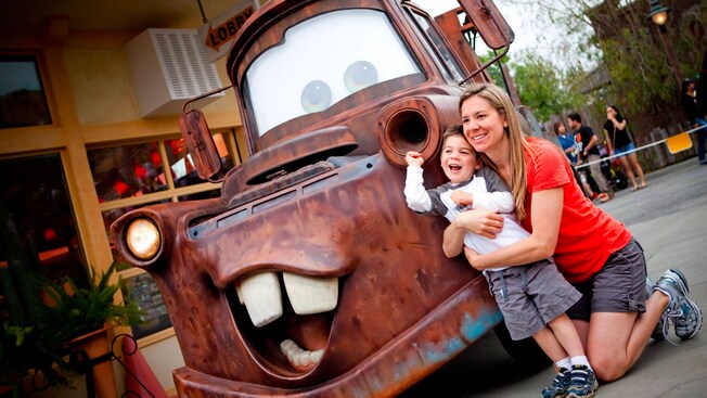 A mother and son pose with Mater in Cars Land