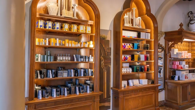 Three wooden display shelves holding fragrances and personal care items inside of Il Bel Cristallo at Epcot