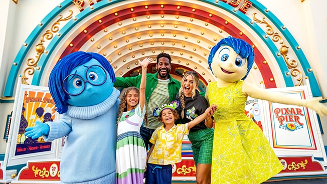 ディズニーとピクサーの映画『インサイド・ヘッド』のキャラクター、ヨロコビとカナシミと写真を撮る家族