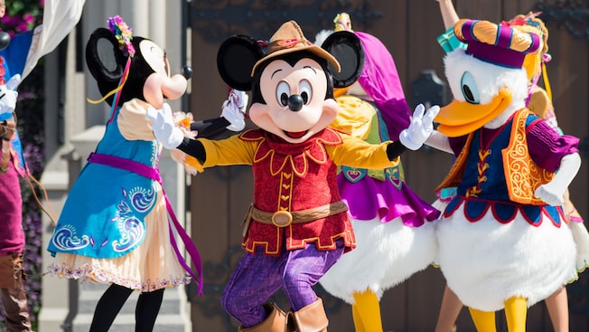 Mickey, Minnie, Donald and Daisy dance in their fancy celebration outfits
