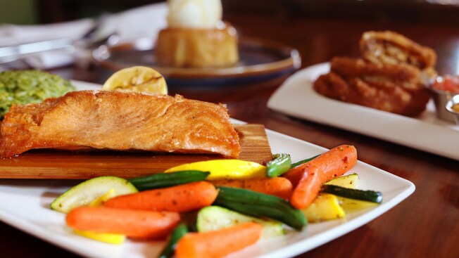 Salmón servido con zanahorias glaseadas con miel y un pastel de piña