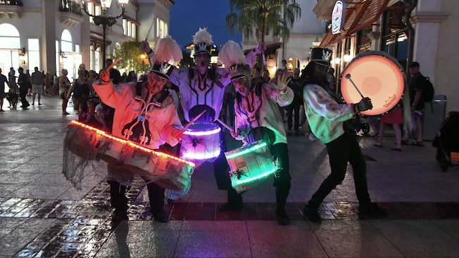 4 drummers dressed like zombies, performing on a promenade in Disney Springs 