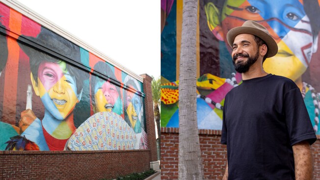 Artist Eduardo Kobra next to his mural featuring a row of smiling children