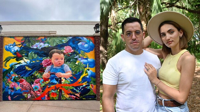 A man and a woman standing near a mural of a little boy sitting among plantlife, birds and butterflies