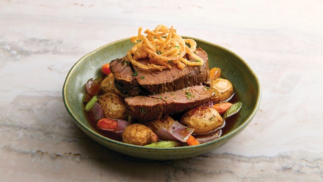 Pot roast with potatoes, carrots and topped with crispy onions 