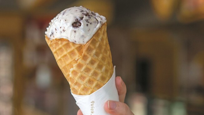 A hand holding an ice cream cone filled with Exquisito Guanabana Stracciatella from Salt & Straw