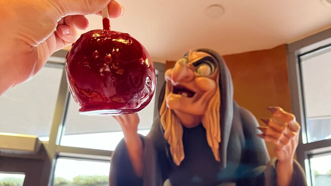 A caramel apple near the witch from Snow White and the Seven Dwarfs at Disney's Candy Cauldron