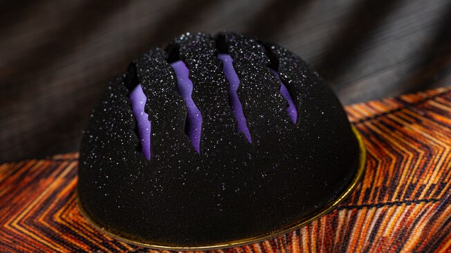 A round chocolate mousse cake with Black Panther claw scratches across the top
