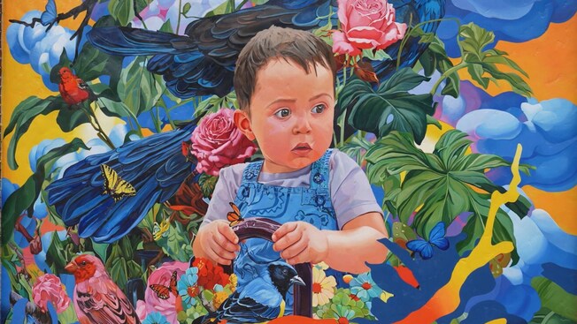 Un mural de un bebé sosteniendo una canasta, rodeado de plantas, pájaros y mariposas