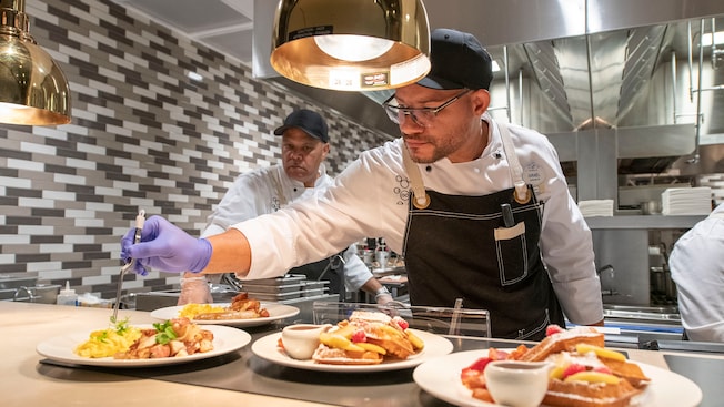 A Disney chef puts the finishing touches on dishes  