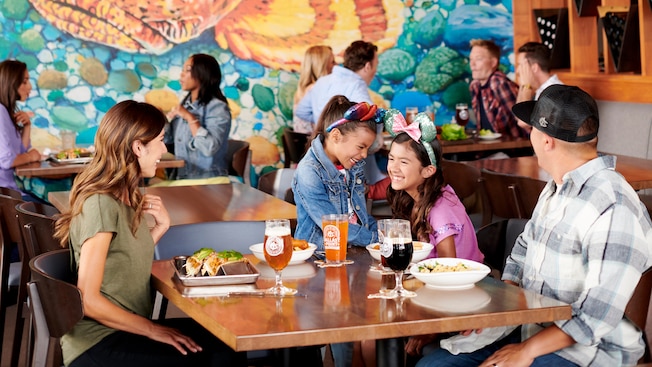 Two girls with Minnie bows at a restaurant table with their parents