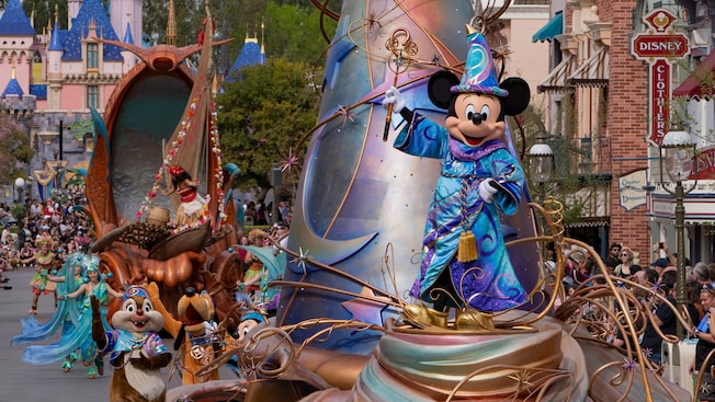 Mickey Mouse con un atuendo de mago en un carro alegórico del desfile que pasa cerca del Castillo de la Bella Durmiente