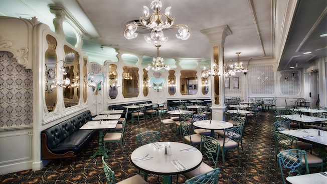 Chandelier, large mirrors, wrought iron tables and chairs of The Plaza Restaurant