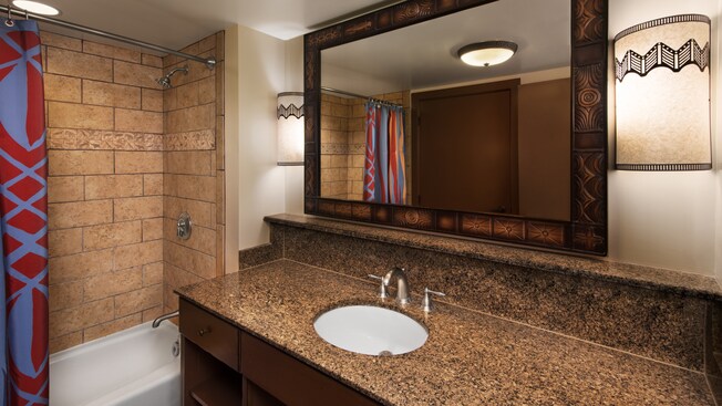 Um banheiro com decoração com tema africano e chuveiro com banheira