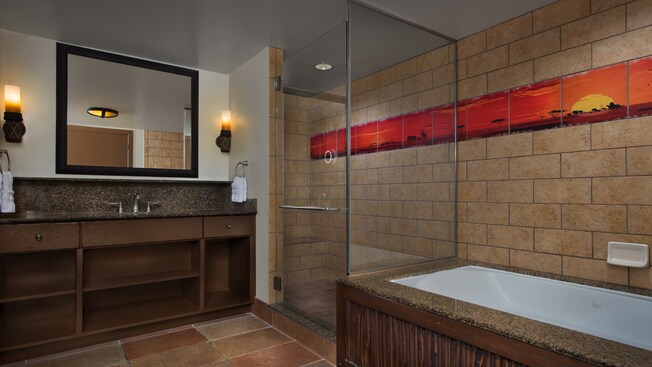 Um banheiro com chuveiro e banheira separados, azulejo decorativo com tema africano