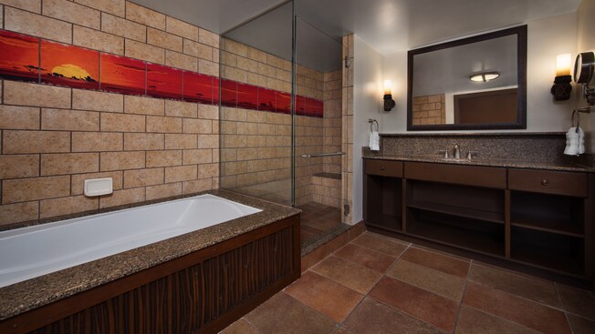 Um banheiro com chuveiro e banheira separados e azulejo decorativo com tema africano