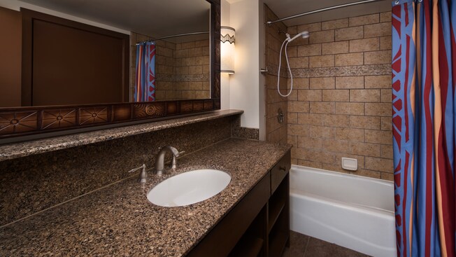 Um banheiro com decoração com tema africano, incluindo chuveiro com banheira