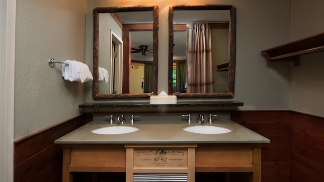 Rustic bathroom double vanity with rough-hewn wood-framed wall mirrors and decorative washboard