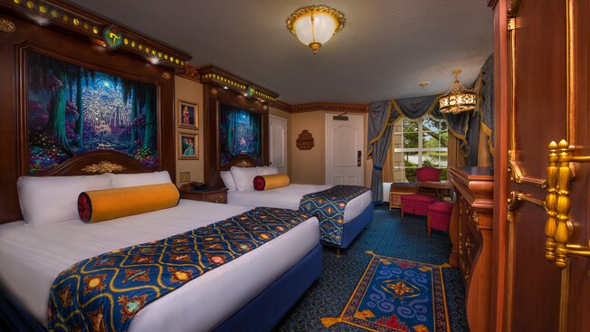 Royal bedroom with 2 beds, elaborate headboards and ornate styling, and curtained river view