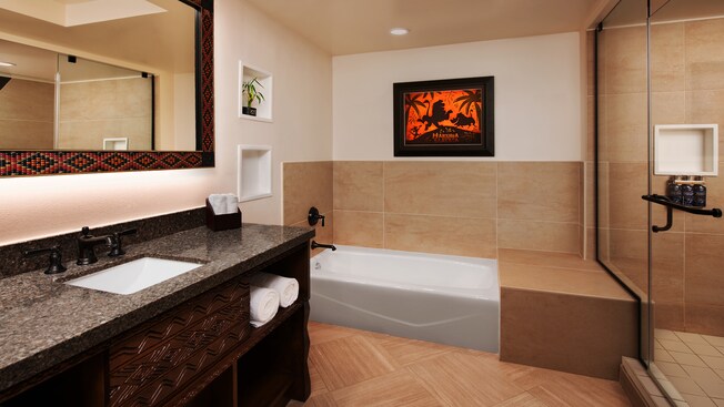 Bathroom with a sink, a vanity, towels, a bathtub and a shower