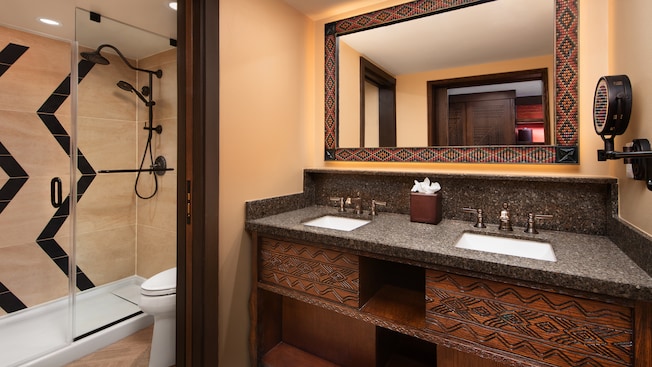 Bathroom with a double sink vanity, a toilet and a bathtub shower combo