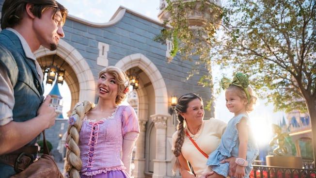 A mother holding her daughter during a Character Greeting with Rapunzel and Flynn in Fantasyland