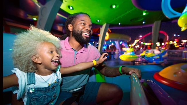 A man and his daughter riding on Alien Swirling Saucers